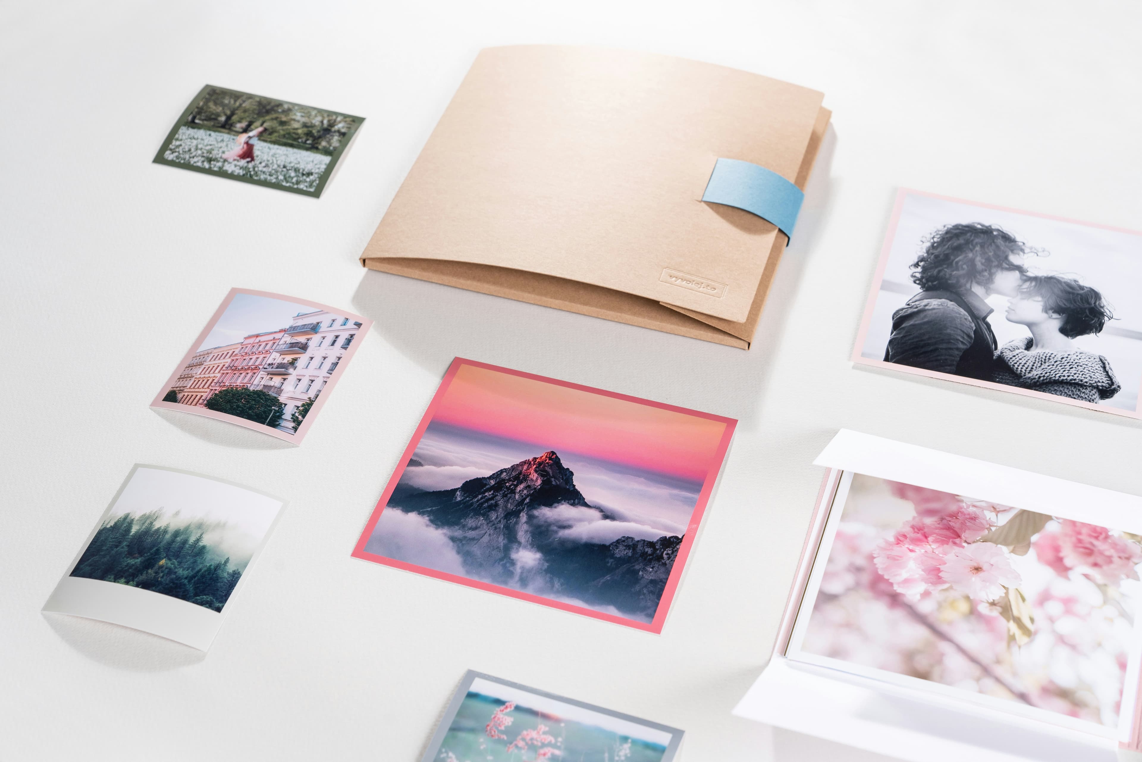 A white table topped with pictures and a book