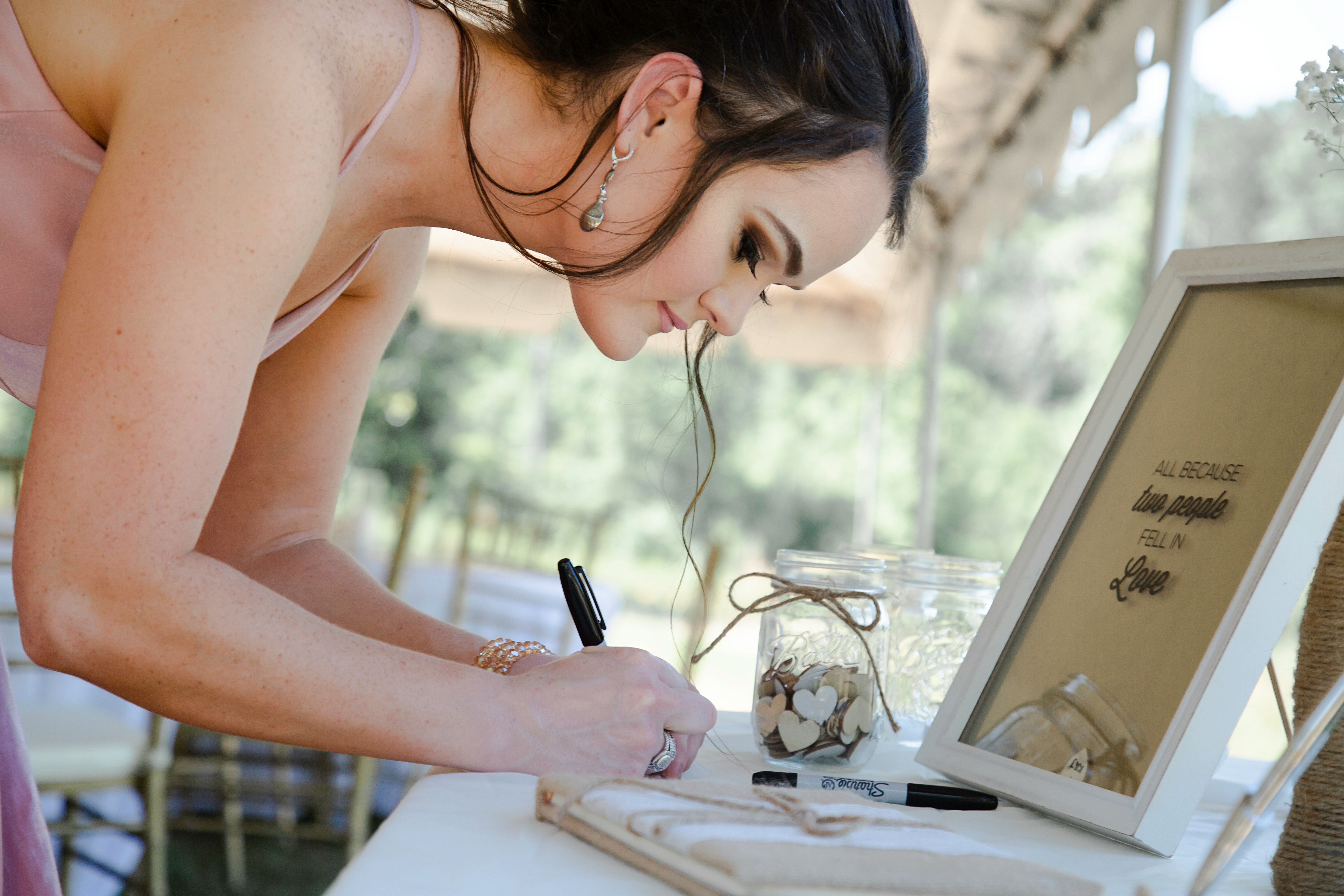A guest writing in a wedding guestbook.