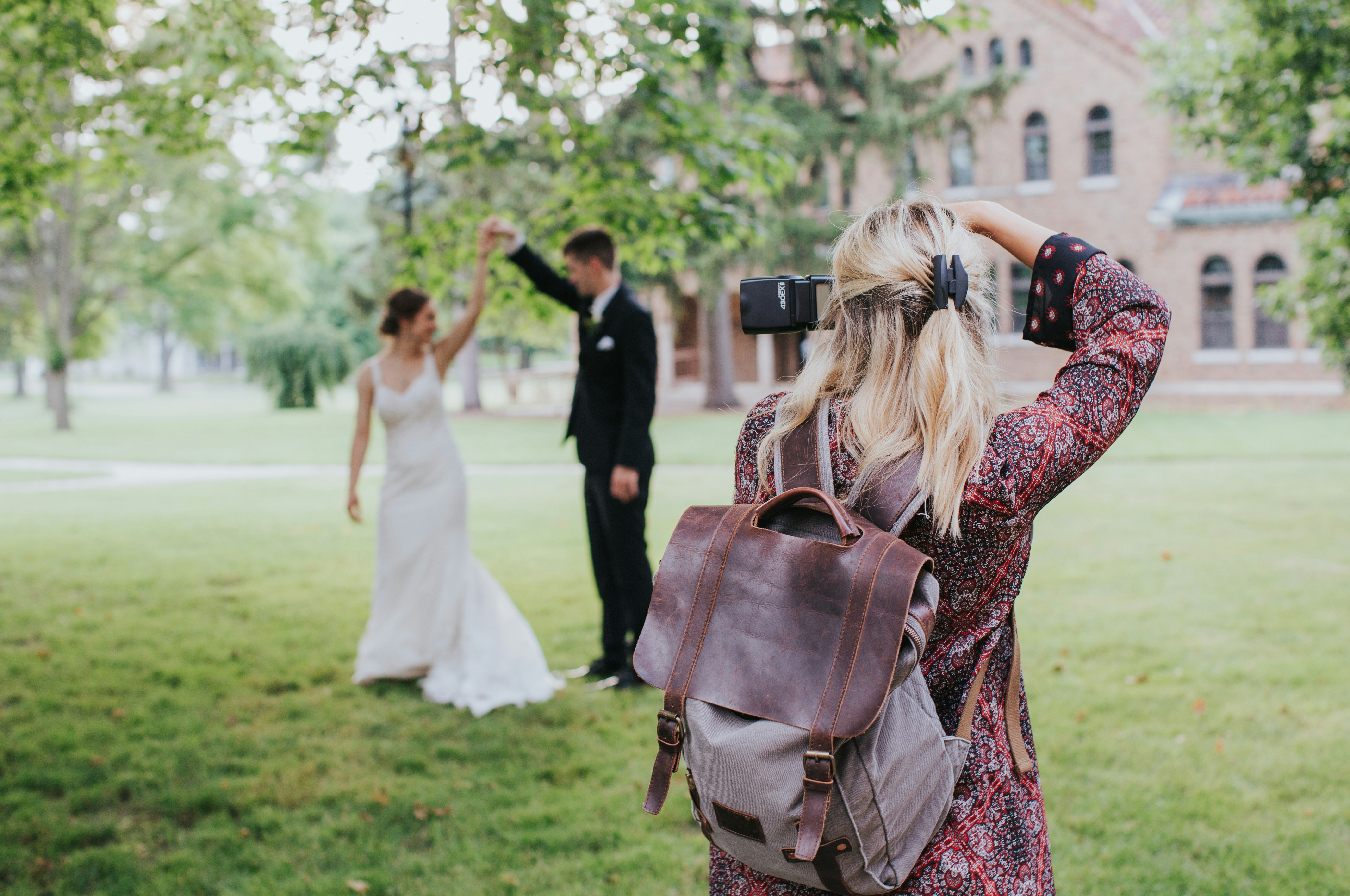Woman in red and black floral dress carrying a black leather shoulder bag